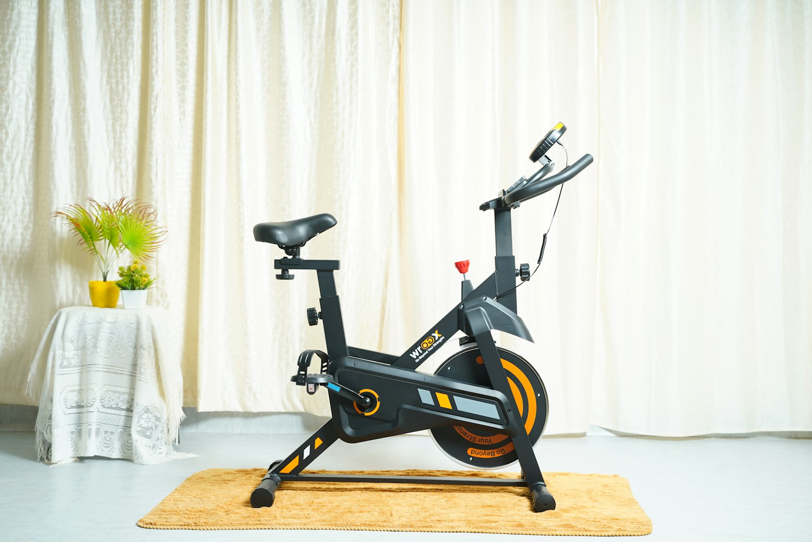 Black stationary exercise bike on a rug in a living room