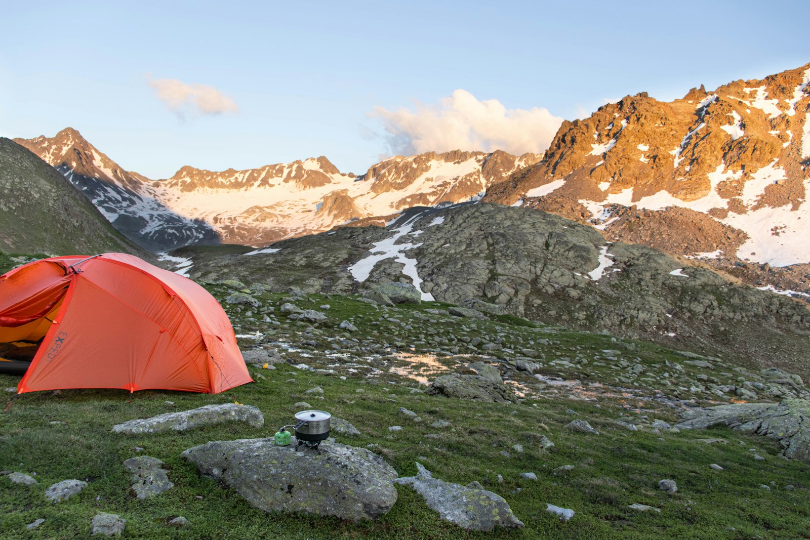 Camping tent pitched on a mountain with mountains behind